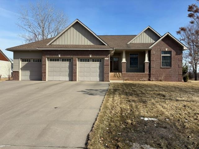 craftsman-style home with driveway, brick siding, board and batten siding, and an attached garage