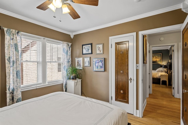 bedroom featuring light wood-type flooring, baseboards, a ceiling fan, and ornamental molding