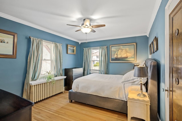 bedroom featuring crown molding, wood finished floors, radiator, and multiple windows