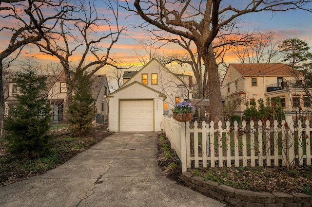 traditional home with concrete driveway, stucco siding, fence, and central AC