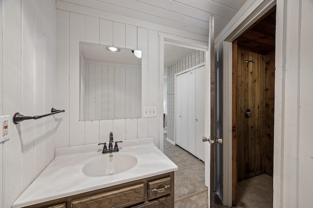 bathroom with wood walls and vanity