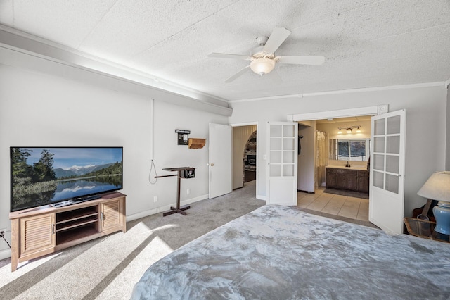 bedroom with carpet floors, french doors, ensuite bathroom, a ceiling fan, and a textured ceiling