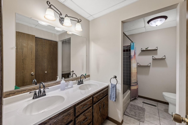 full bath featuring toilet, tile patterned flooring, double vanity, and a sink