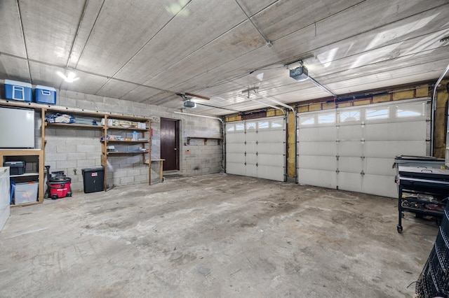 garage with concrete block wall and a garage door opener