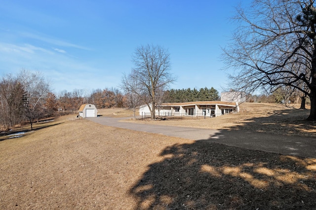 exterior space featuring a garage, an outbuilding, covered porch, and driveway