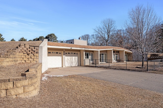 single story home featuring concrete driveway, a chimney, an attached garage, fence, and stucco siding