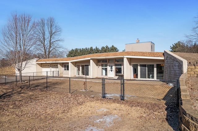 view of front of house featuring a shingled roof, a fenced front yard, and a chimney