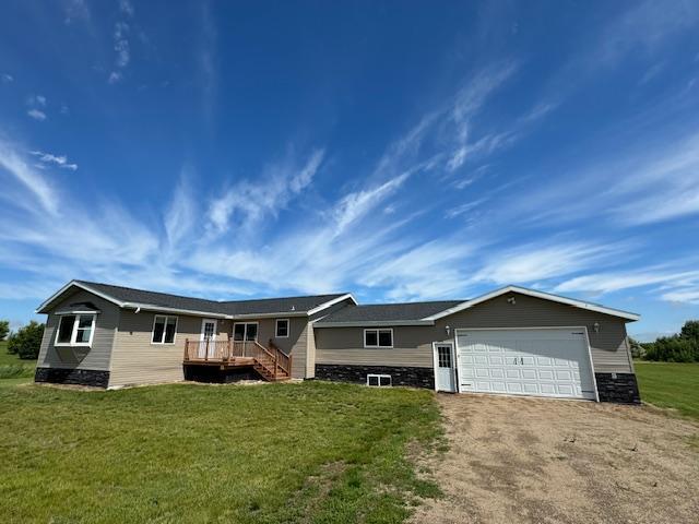 ranch-style home featuring driveway, a front lawn, and an attached garage