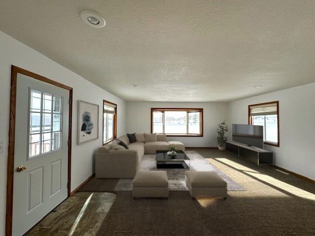 carpeted living room with a textured ceiling and baseboards