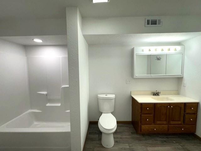 bathroom featuring baseboards, visible vents, toilet, wood finished floors, and vanity