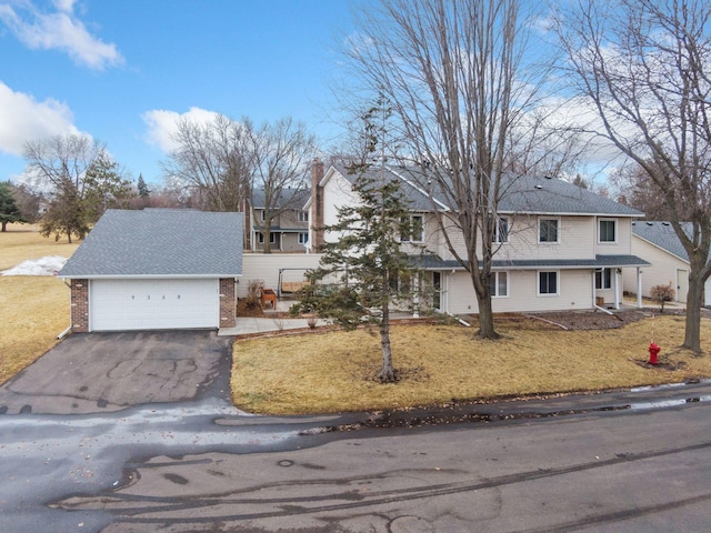 view of front of home with a garage, brick siding, driveway, and a front lawn