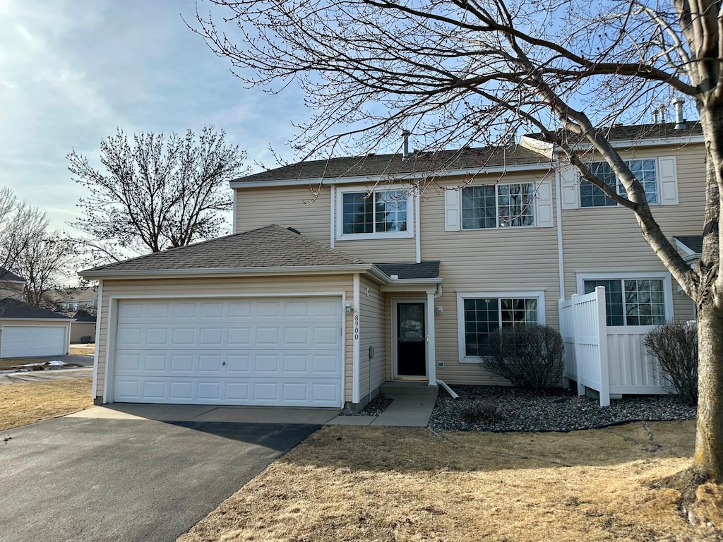 view of front facade with aphalt driveway, a shingled roof, and a garage