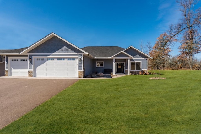 craftsman inspired home with stone siding, aphalt driveway, a front yard, and a garage