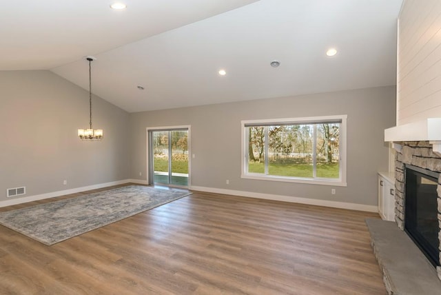 unfurnished living room featuring vaulted ceiling, a fireplace, baseboards, a notable chandelier, and visible vents