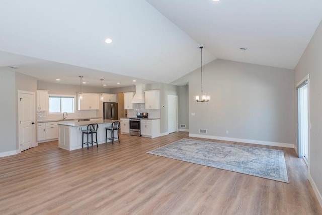 unfurnished living room with a sink, light wood-type flooring, baseboards, a notable chandelier, and recessed lighting