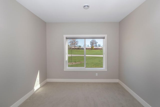 empty room featuring visible vents, light carpet, and baseboards