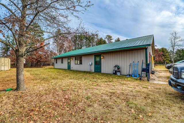 exterior space featuring metal roof and a yard