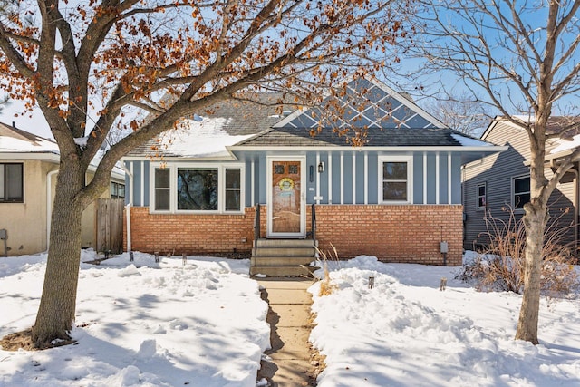 bungalow-style home with brick siding and fence