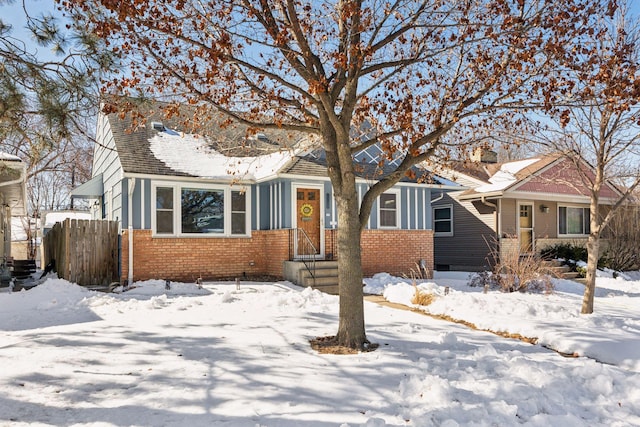 view of front of property featuring brick siding and fence