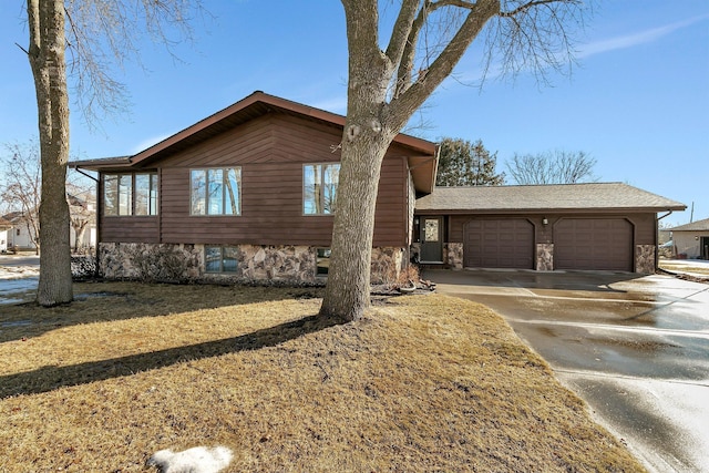 view of front facade featuring an attached garage, driveway, roof with shingles, and stone siding