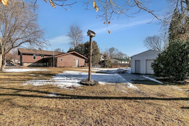 view of yard with a detached garage and an outdoor structure