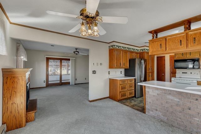 kitchen with brown cabinets, light countertops, stove, freestanding refrigerator, and black microwave