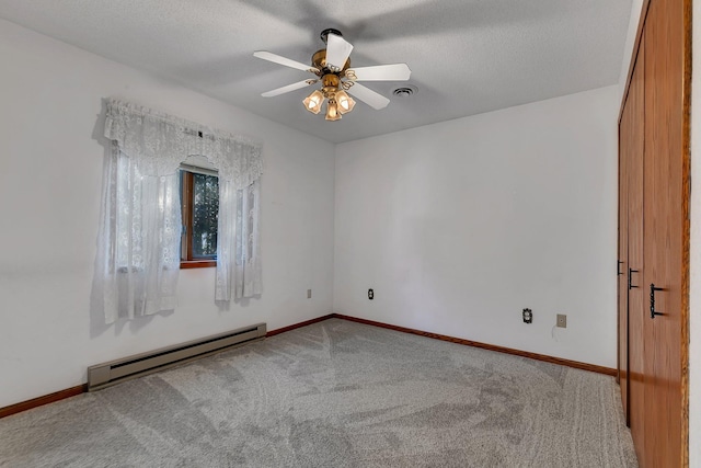 carpeted spare room featuring a baseboard radiator, visible vents, ceiling fan, a textured ceiling, and baseboards