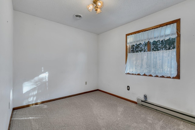 carpeted spare room featuring baseboards, visible vents, a baseboard heating unit, and a textured ceiling