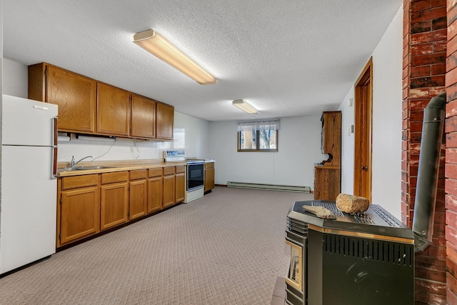 kitchen featuring brown cabinets, electric range oven, a baseboard heating unit, freestanding refrigerator, and a sink