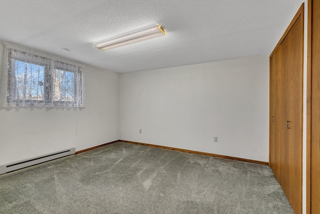 unfurnished bedroom featuring carpet floors, a baseboard radiator, baseboards, and a textured ceiling