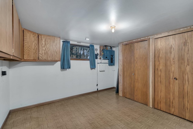 basement with electric panel and baseboards