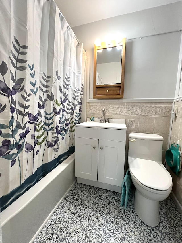 full bathroom featuring wainscoting, toilet, shower / tub combo with curtain, tile patterned floors, and tile walls