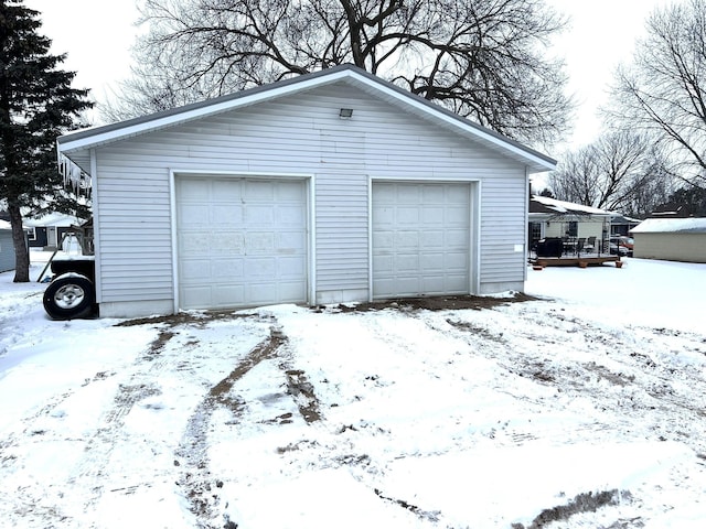 snow covered garage featuring a detached garage