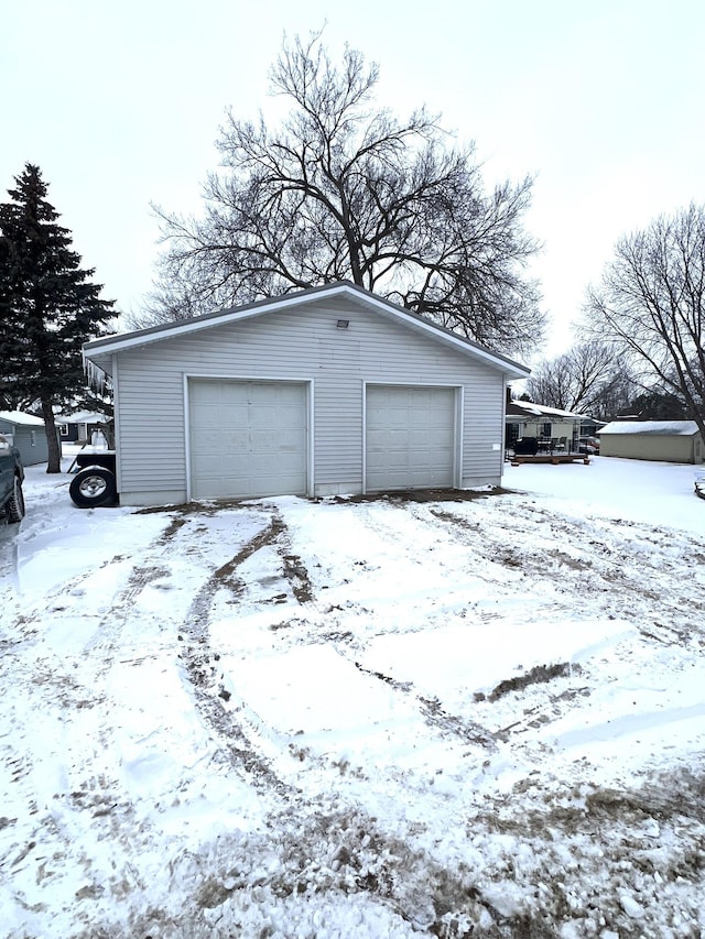 snow covered garage with a detached garage