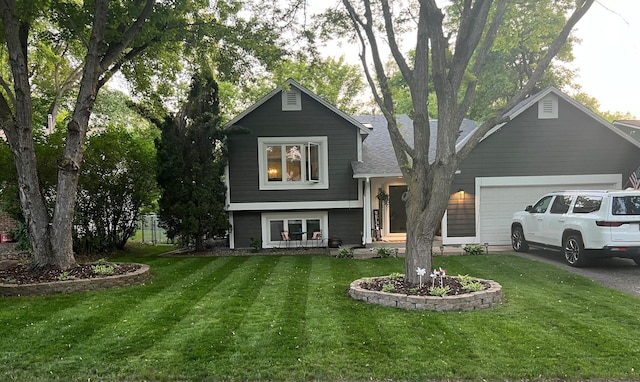 view of front of property with a garage, driveway, a shingled roof, and a front lawn