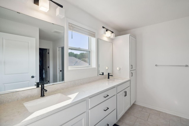 full bath featuring visible vents, a sink, baseboards, and double vanity