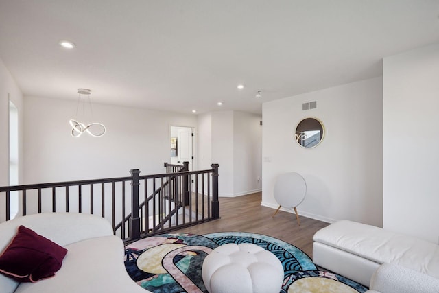 interior space featuring baseboards, visible vents, wood finished floors, and recessed lighting