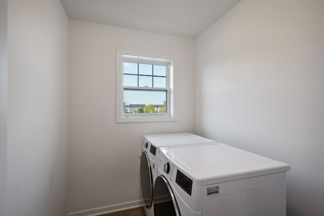 clothes washing area with laundry area, washer and clothes dryer, and baseboards