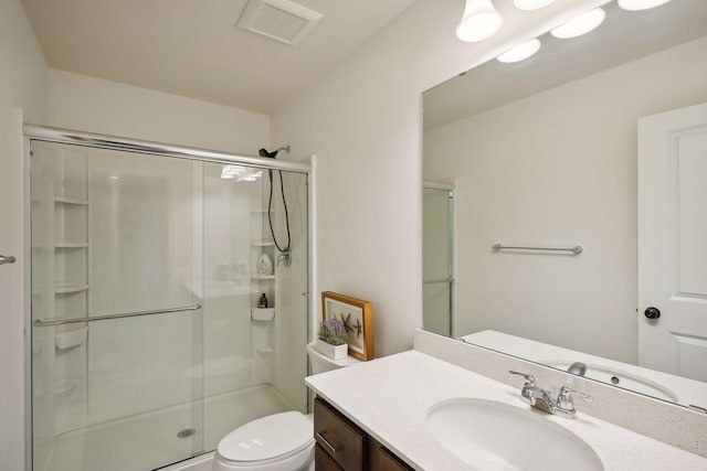 full bathroom featuring toilet, a stall shower, visible vents, and vanity