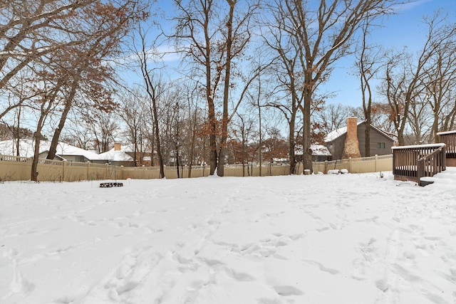 yard layered in snow featuring a fenced backyard