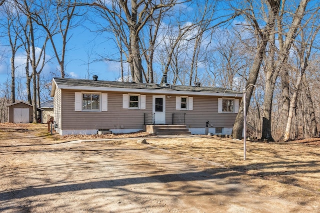 view of front of property featuring an outdoor structure and a shed