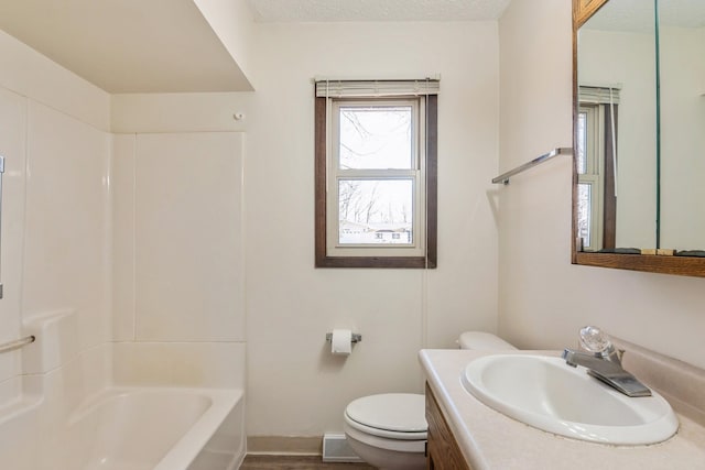 bathroom featuring baseboards, toilet, vanity, bathing tub / shower combination, and a textured ceiling