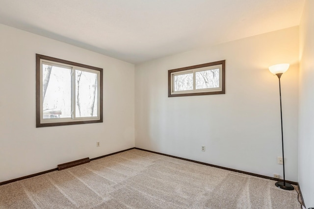 spare room featuring visible vents, carpet, baseboards, and a healthy amount of sunlight