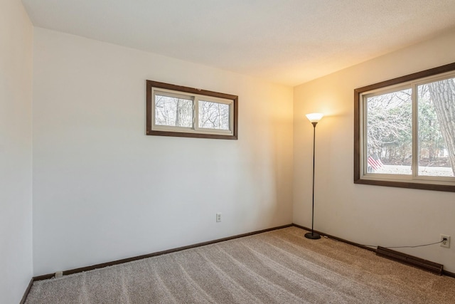 unfurnished room with baseboards and carpet flooring