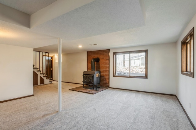 basement with stairway, a wood stove, and baseboards