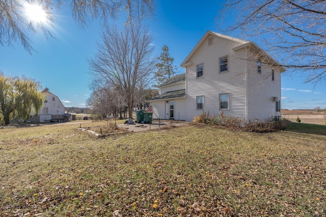 rear view of house with a patio and a lawn