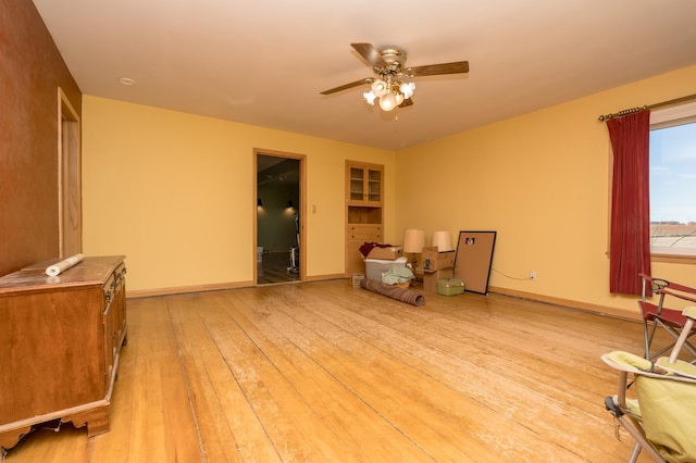 sitting room featuring a ceiling fan, light wood-type flooring, and baseboards