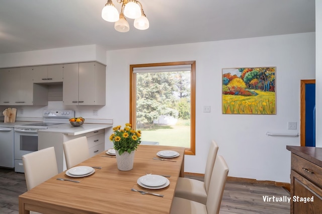 dining space featuring baseboards, wood finished floors, and a notable chandelier