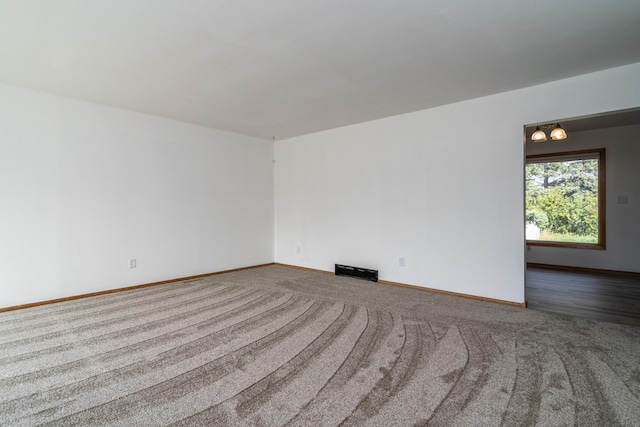 carpeted empty room with visible vents and baseboards