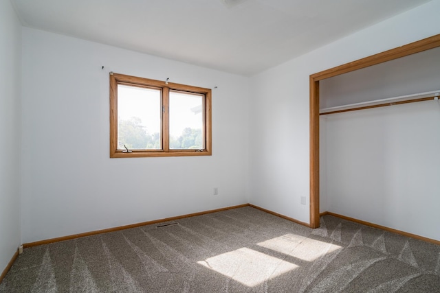 unfurnished bedroom with a closet, carpet flooring, and baseboards